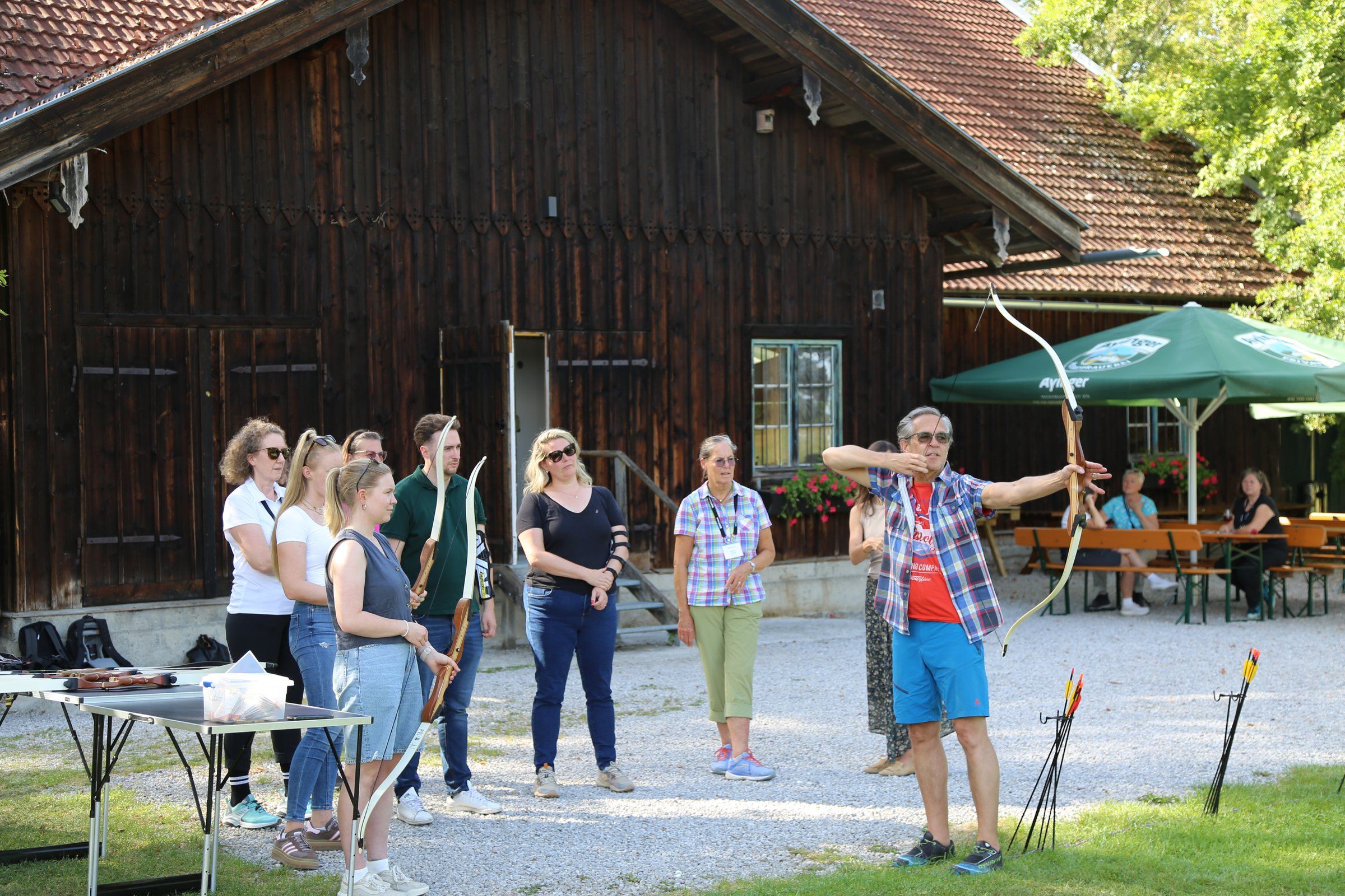Ein Trainer zeigt der Gruppe, wie man den Bogen spannt