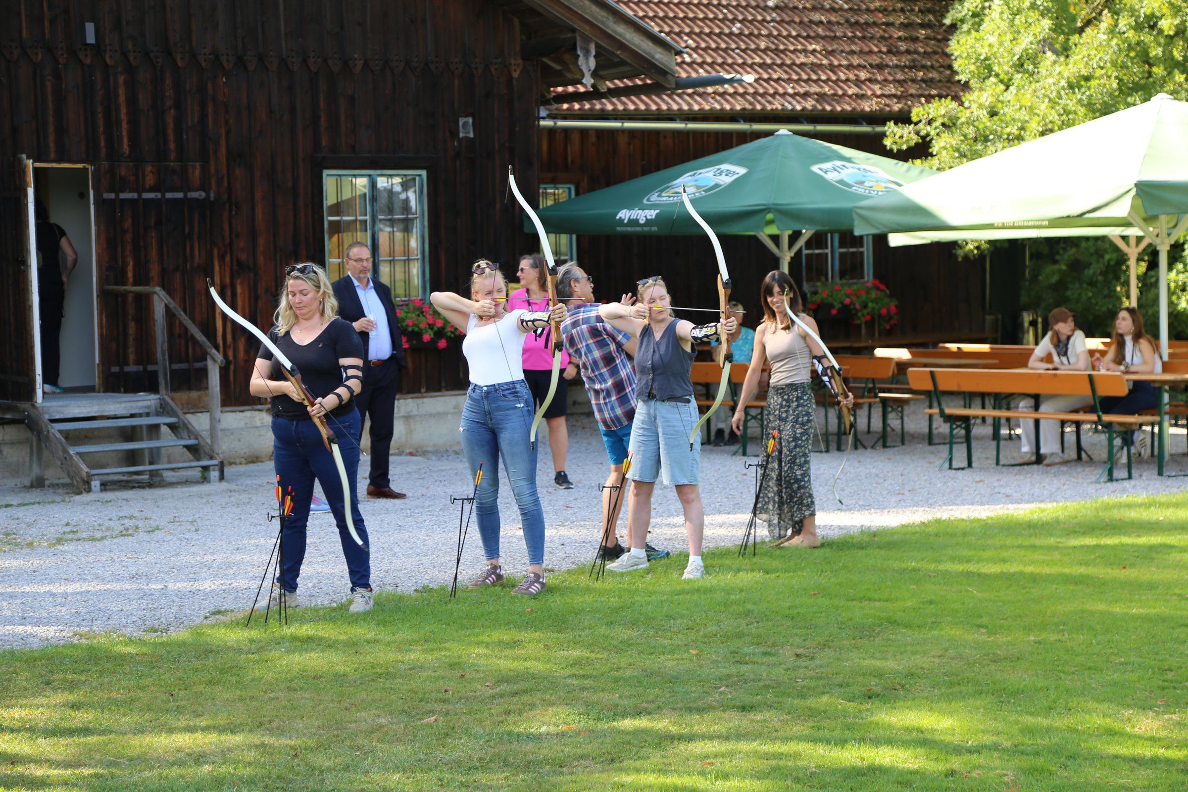 Team beim Bogenschießen auf der Wiese vor der EVENTSCHEUNE