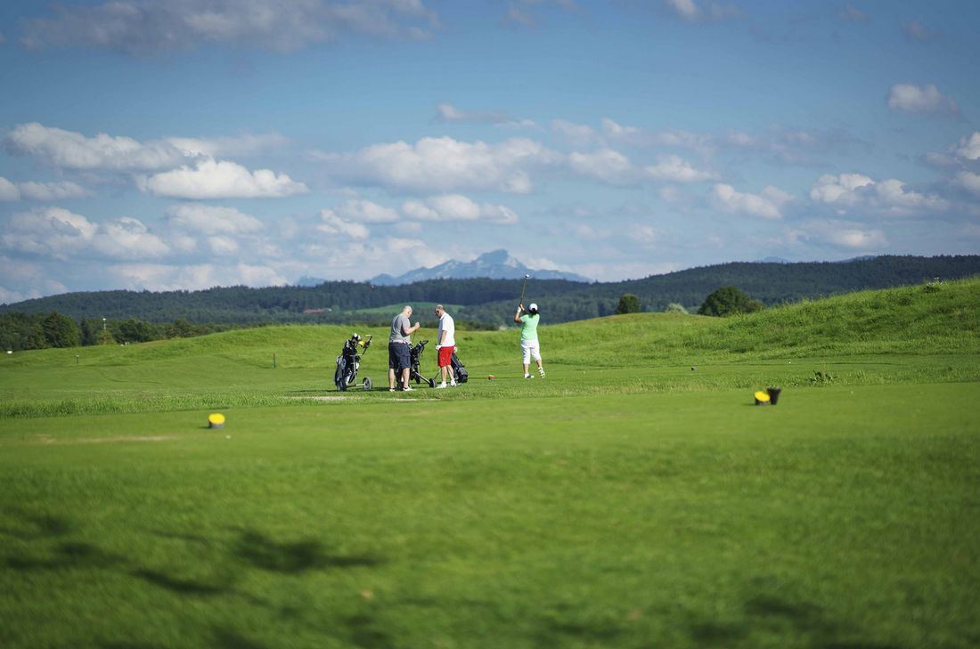 Golfspieler auf einem Grün mit Bergblick