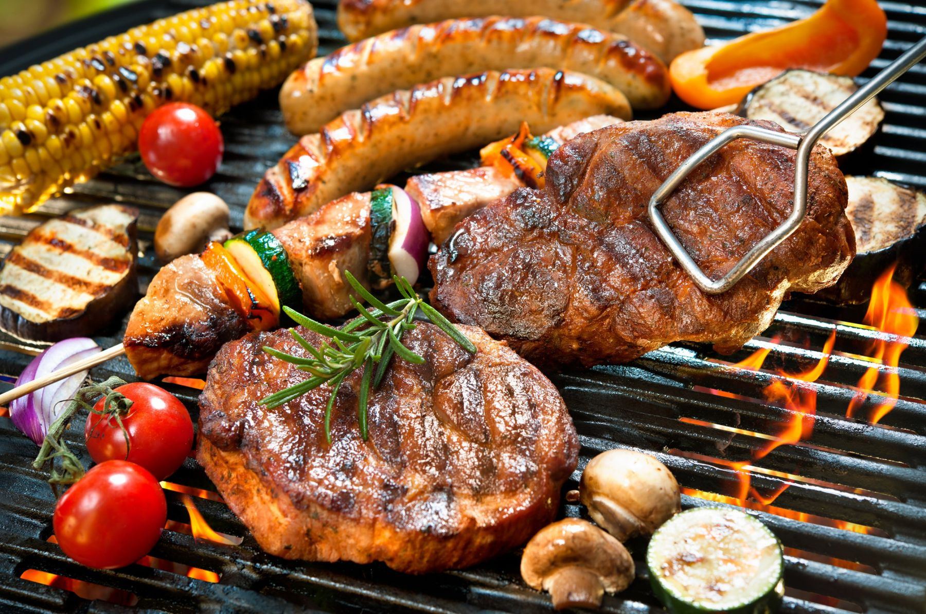 Steaks, Würstl, Spieße und Gemüse auf dem Grill