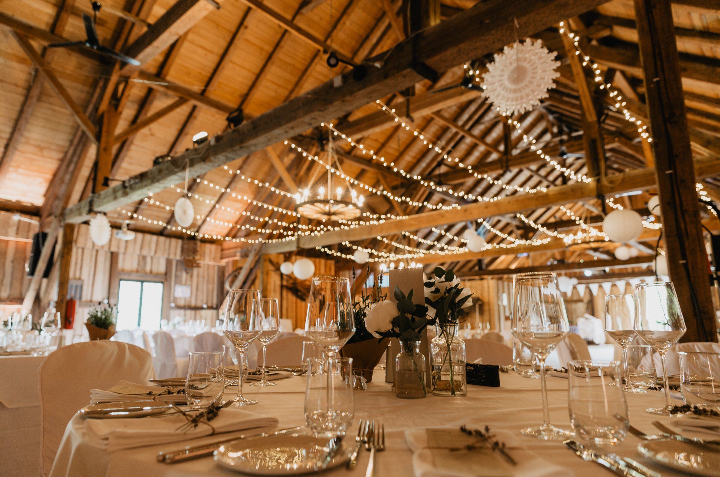 The EVENTSCHEUNE Wallenburg with string lights and set tables
