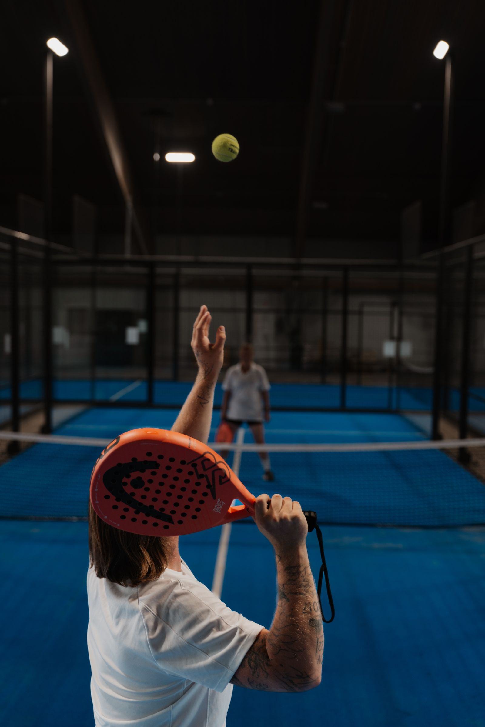 Ein Spieler schlägt auf dem Padelcourt