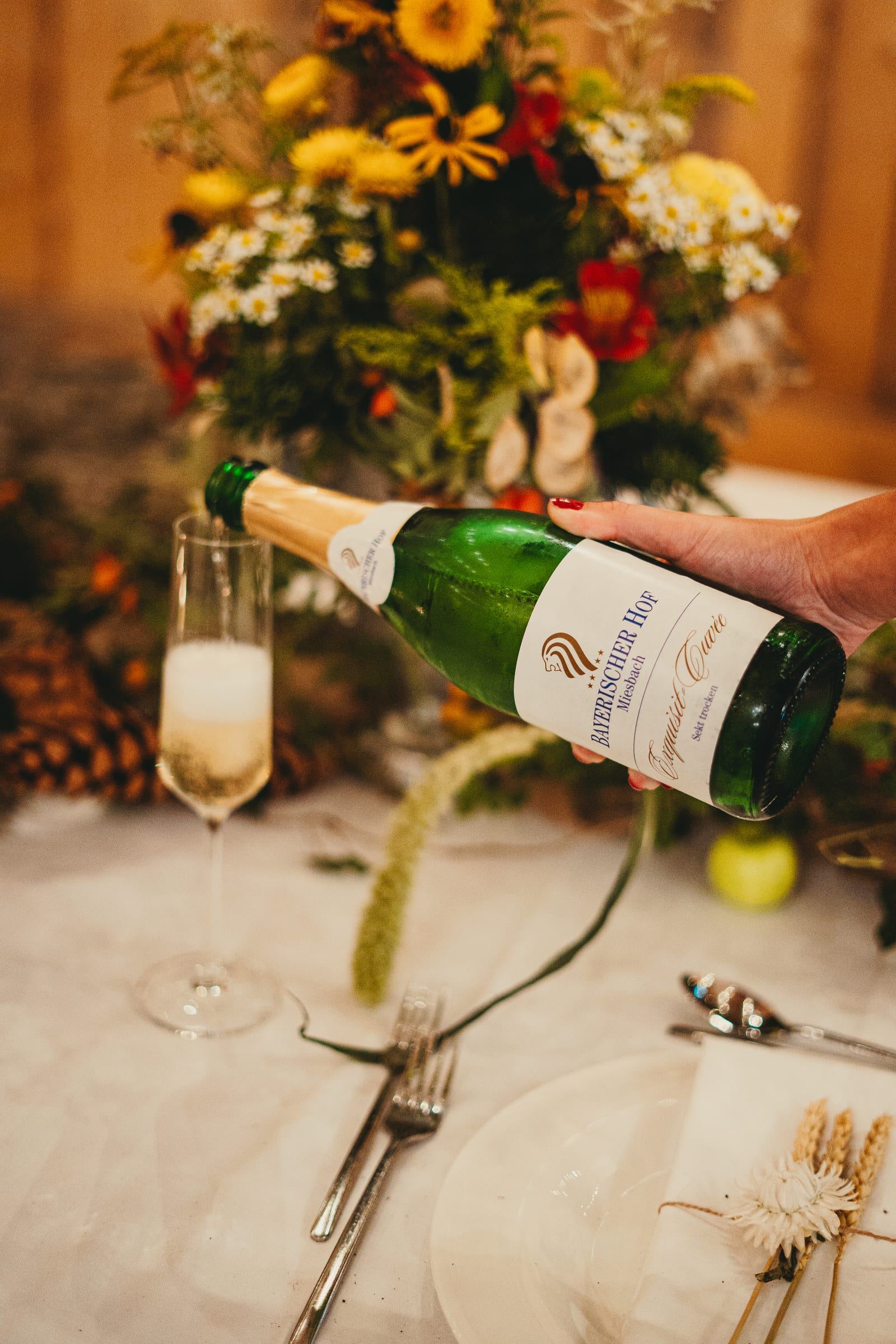 Sekt des Bayerischen Hofs wird an einer festlich gedeckten Tafel eingeschenkt