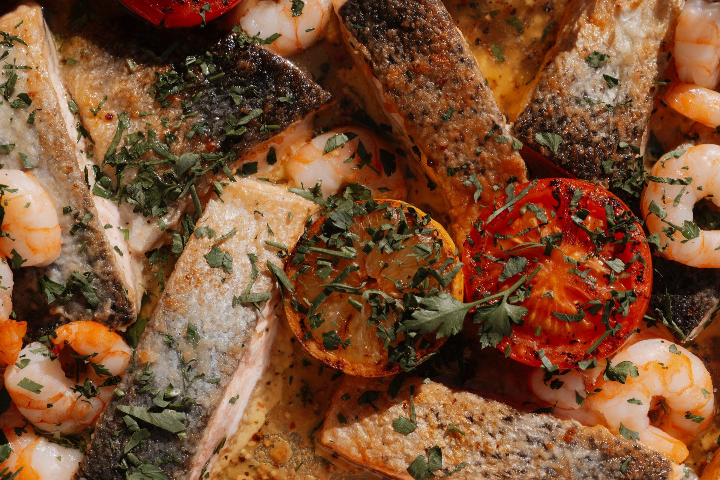 Gebratene Fischfilets mit Garnelen und Tomaten