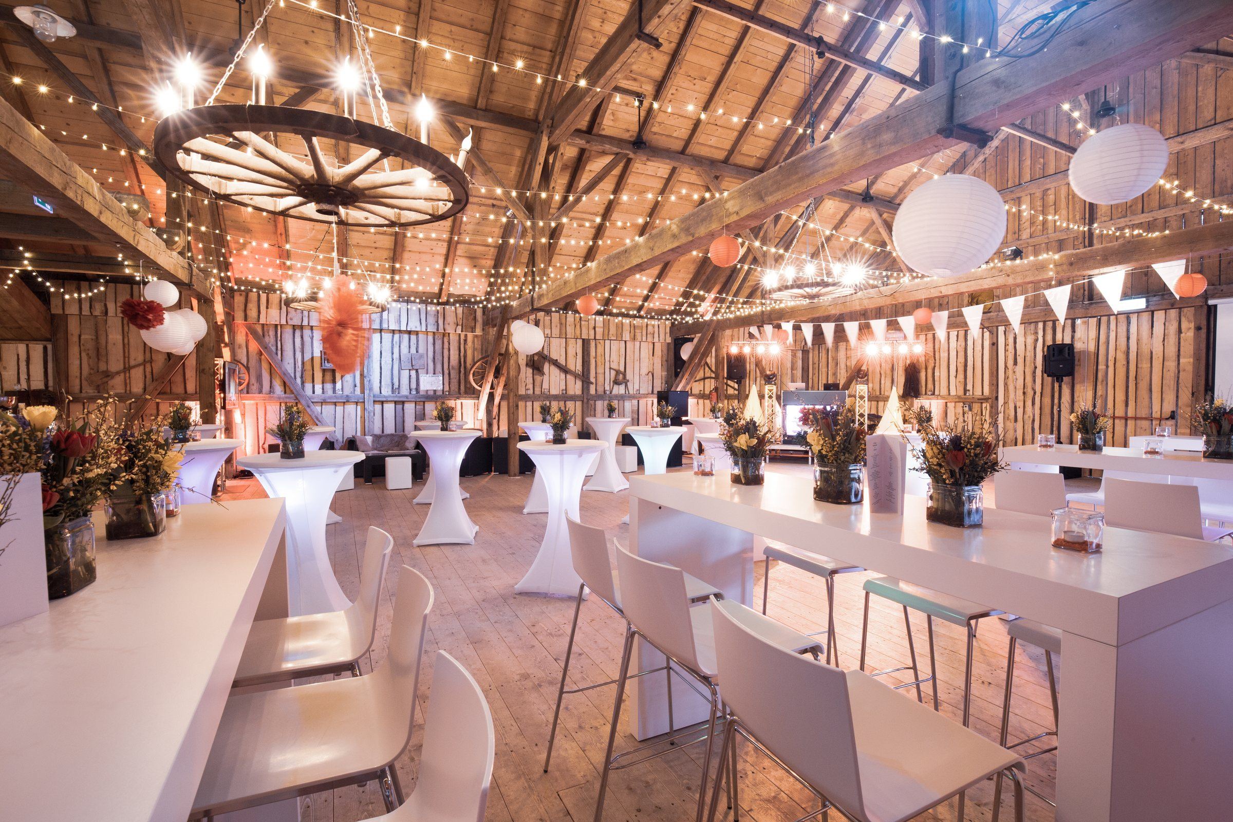 The EVENTSCHEUNE with cocktail tables, paper lanterns and bunting