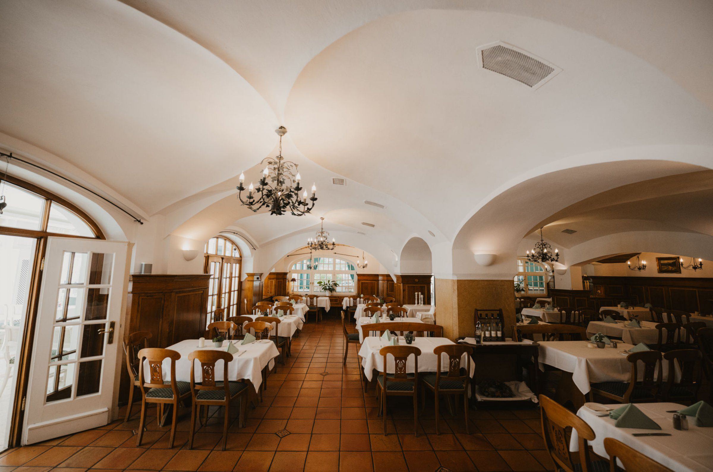 Die Miesbacher Stube mit Gewölbe, Kronleuchtern und gedeckten Tischen