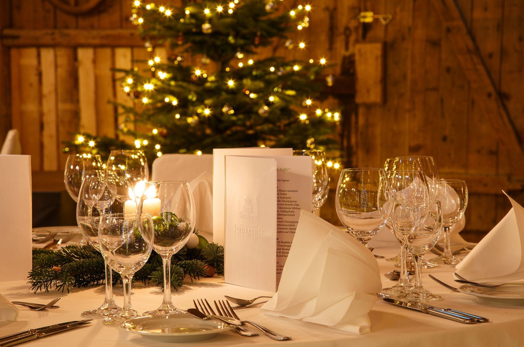 Weihnachtlich gedeckte Tafel vor dem Christbaum